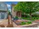 Landscaped front yard featuring a charming brick home, lush greenery, and a quaint garden bed at 3322 W 26Th Ave, Denver, CO 80211