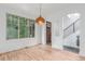 Open-concept living space featuring hardwood floors, white walls, and staircase with metal railings, and natural light at 3322 W 26Th Ave, Denver, CO 80211