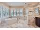 Bright bathroom featuring marble floors, soaking tub, and large glass shower at 770 International Isle Dr, Castle Rock, CO 80108