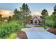 Beautiful home with a stone and brick facade, manicured lawn, and mature trees in a serene setting at 770 International Isle Dr, Castle Rock, CO 80108