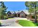 Beautiful home with a brick and stone facade, manicured lawn, and a circular driveway at 770 International Isle Dr, Castle Rock, CO 80108