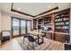 Executive office featuring custom built-in shelving, a large desk, and a balcony with scenic views at 770 International Isle Dr, Castle Rock, CO 80108