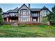 Spacious rear exterior with stone accents, outdoor fireplace, large windows, and grassy yard at 770 International Isle Dr, Castle Rock, CO 80108