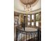 Elegant curved staircase with stone walls and a wrought iron railing, leading to the upper levels of the home at 770 International Isle Dr, Castle Rock, CO 80108