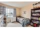 Well-lit bedroom with a twin bed, a large window, and built-in shelving at 9606 Adelaide Cir, Highlands Ranch, CO 80130