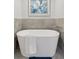 Elegant white bathtub with a modern faucet, complemented by tiled walls and a decorative painting, for a spa-like feel at 4094 Bimini Ct, Boulder, CO 80301