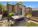 Backyard patio with table and garden bed against a brick house at 2435 N Irving St, Denver, CO 80211