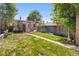A spacious backyard with a stone path, patio, and landscaped garden area at 2435 N Irving St, Denver, CO 80211