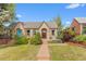 Charming brick home with a well-manicured lawn and inviting front porch seating at 2435 N Irving St, Denver, CO 80211