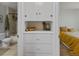 A hallway with storage and a view into a bedroom and adjacent tiled bathroom at 2435 N Irving St, Denver, CO 80211