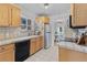 Traditional kitchen with light wood cabinets, tiled countertops, and a black dishwasher at 2435 N Irving St, Denver, CO 80211