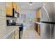 Functional kitchen with modern stainless steel refrigerator and tile countertops at 2435 N Irving St, Denver, CO 80211
