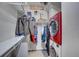 Functional walk-in closet with shelves and clothing racks. A red dryer and washing machine are featured at 1435 Wazee St # 408, Denver, CO 80202