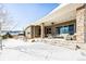 House exterior with covered patio and snowy landscape at 18722 W 87Th Ave, Arvada, CO 80007