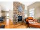 Living room fireplace with stone surround and leather armchairs at 18722 W 87Th Ave, Arvada, CO 80007