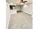Spacious living room featuring new carpet, adjacent kitchen area, and ceiling fan at 64 Nome Way # C, Aurora, CO 80012