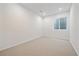 Unfinished basement with egress window and neutral carpet at 1626 S Sherman St, Denver, CO 80210