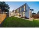 Modern home with a large lawn, a patio, and large windows showcasing the interior at 1626 S Sherman St, Denver, CO 80210