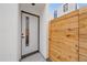 A modern white front door with a full-length glass insert and natural wood fence at 1626 S Sherman St, Denver, CO 80210