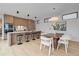 Modern kitchen with sleek cabinets, stainless steel appliances, and island seating adjacent to dining area at 1626 S Sherman St, Denver, CO 80210