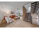 Bright, open-concept living room boasts hardwood floors, stylish decor, and a staircase with unique wood screen detail at 1626 S Sherman St, Denver, CO 80210
