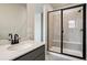 Modern bathroom with glass-enclosed shower, gray vanity, quartz countertop, black faucet, and rectangular sink at 14135 Deertrack Ln, Parker, CO 80134
