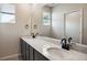 Bathroom featuring dual sinks, modern faucet fixtures, sleek vanity, a large mirror and window at 14135 Deertrack Ln, Parker, CO 80134