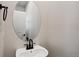 Powder room with pedestal sink, rounded mirror, black faucet, and white walls at 14135 Deertrack Ln, Parker, CO 80134