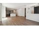 Open-concept living space with hardwood floors, gray kitchen with island, and staircase in background at 14135 Deertrack Ln, Parker, CO 80134