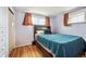 A bedroom featuring hardwood floors, purple walls, and a bed with a blue comforter at 2849 W Vassar Ave, Denver, CO 80219