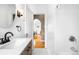 Modern bathroom with dual sink vanity, penny tile floor, and glass shower at 4938 W Hayward Pl, Denver, CO 80212