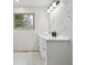 Bathroom features a white vanity, modern lighting, and marble-look tile surround at 7952 Zuni St, Denver, CO 80221