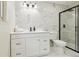 Modern bathroom featuring sleek white vanity, glass shower, and updated tile at 7952 Zuni St, Denver, CO 80221