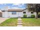 Charming brick home features a well-manicured lawn and welcoming walkway to the front door at 7952 Zuni St, Denver, CO 80221