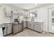 Spacious kitchen with stainless steel refrigerator and modern gray cabinetry at 7952 Zuni St, Denver, CO 80221