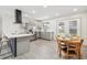 Modern kitchen features gray cabinets, stainless steel appliances, an island, and a dining area with outdoor access at 7952 Zuni St, Denver, CO 80221