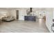 Open-concept living space with modern finishes, featuring light-colored floors and a kitchen island with bar stools at 7952 Zuni St, Denver, CO 80221