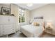 Bright bedroom with a full window, light walls, and ample dresser storage at 1401 Delgany St # 202, Denver, CO 80202