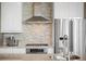Modern kitchen featuring stainless steel appliances, cooktop, and stylish backsplash at 1401 Delgany St # 202, Denver, CO 80202