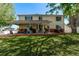 Large backyard featuring a covered patio, spacious lawn, and mature shade trees at 105 Hawthorn St, Frederick, CO 80530