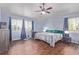 Spacious bedroom with wood-look floors, ceiling fan, and windows with blue drapes at 105 Hawthorn St, Frederick, CO 80530