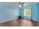 Bedroom featuring wood-look floors, blue walls, and large window with curtains at 105 Hawthorn St, Frederick, CO 80530