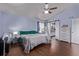 Bright bedroom featuring wood-look floors, ceiling fan, and sliding barn door to bathroom at 105 Hawthorn St, Frederick, CO 80530