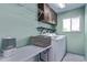 Functional laundry room includes washer, dryer, shelving and ample counter space at 105 Hawthorn St, Frederick, CO 80530