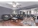 Open-concept living room flowing into the kitchen with dark leather couches and hardwood flooring at 105 Hawthorn St, Frederick, CO 80530