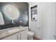 Stylish powder room featuring modern fixtures and a round mirror at 4214 E 8Th Pl, Denver, CO 80220