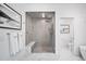 Modern shower with glass doors, marble floors, and bench seat at 4214 E 8Th Pl, Denver, CO 80220