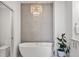 Bathroom featuring stand alone soaking tub and modern chandelier at 4214 E 8Th Pl, Denver, CO 80220