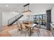 Dining area with modern table, chairs, and chandelier, and a black metal stair railing at 4214 E 8Th Pl, Denver, CO 80220