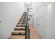 Hallway with wooden floating staircase, skylight, and white storage closets at 4214 E 8Th Pl, Denver, CO 80220